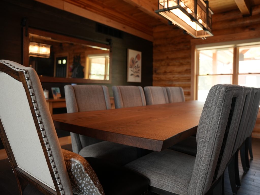 A picture of a dining room table and chairs in a log home
