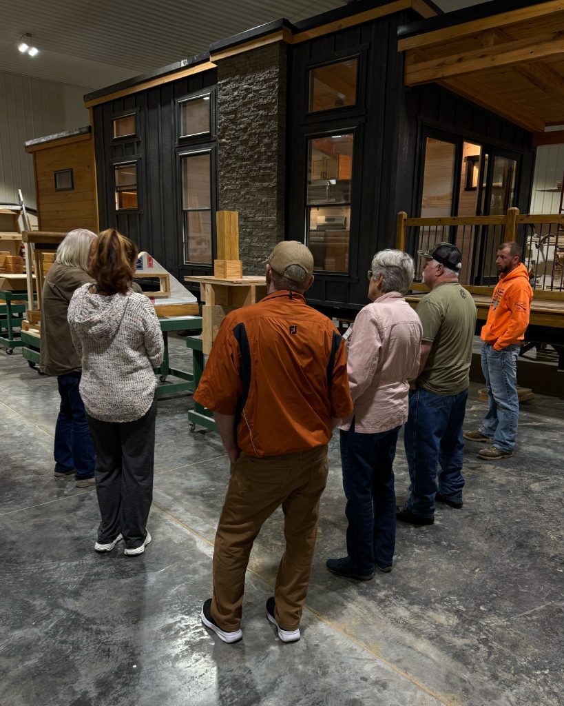 Several people looking at a tiny cabin