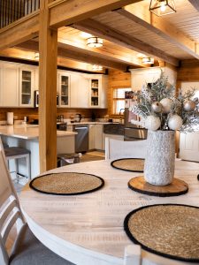 Picture of a dining room table with a kitchen in the background